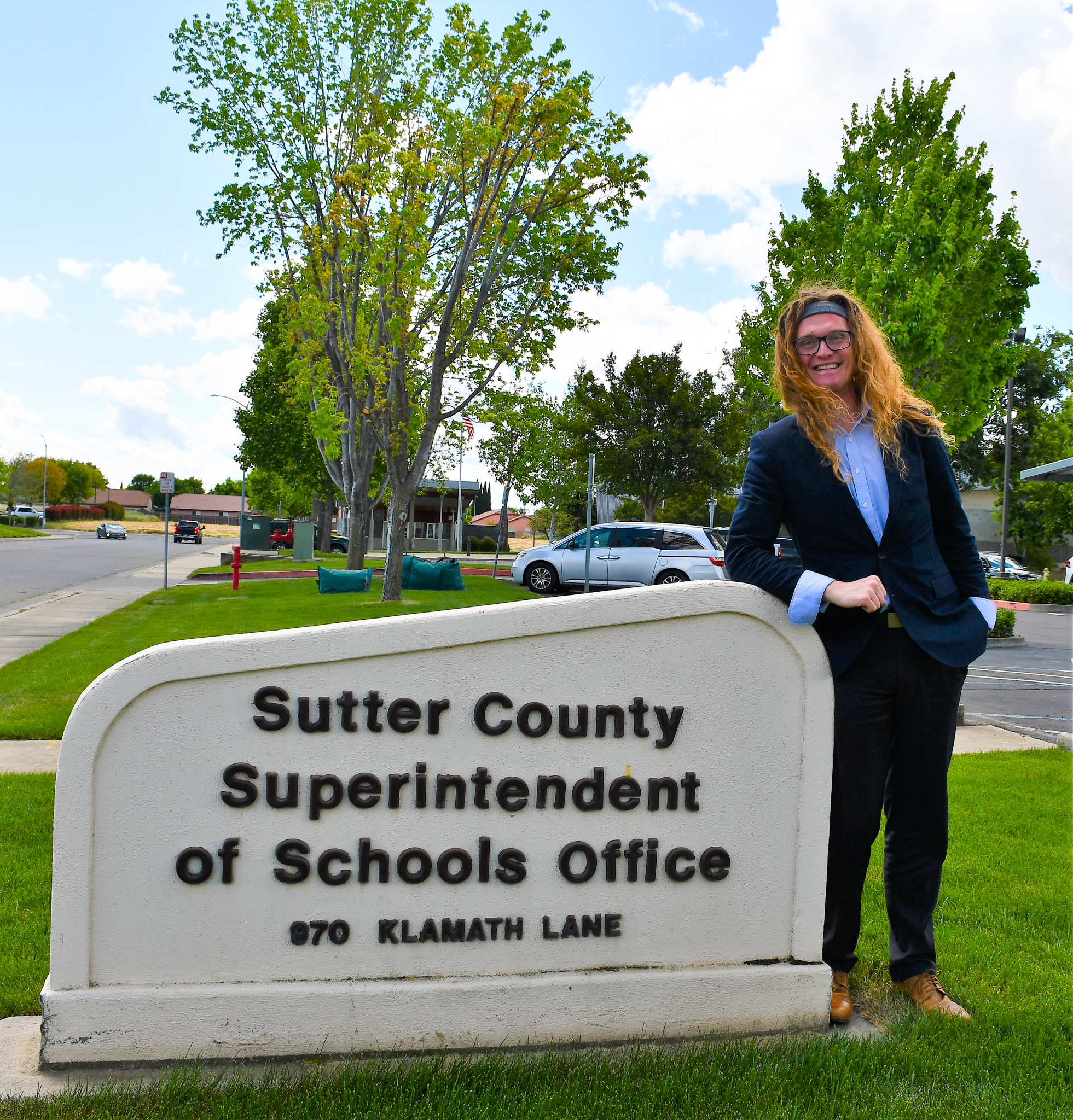 Photo of Shady Creek Director Christopher Little posing next to the SCSOS sign